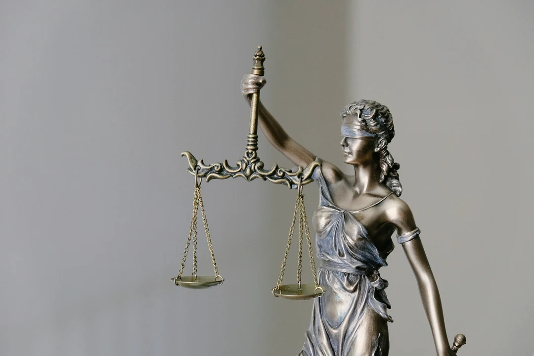 Estátua da justiça com venda nos olhos e balança, simbolizando imparcialidade e direito.